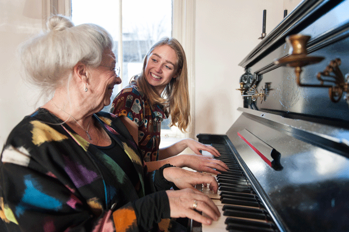 Бабушка и внучка играют на фортепиано